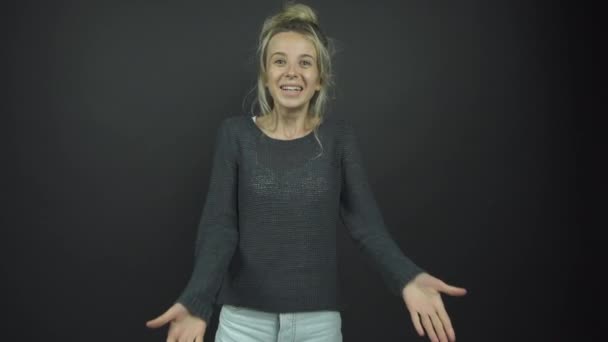 Dame in grijs pullover schudt handen en glimlacht met geluk — Stockvideo