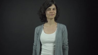 Aktris, çenesine el ele tutuşan düşünceli bir kadın rolü oynar.