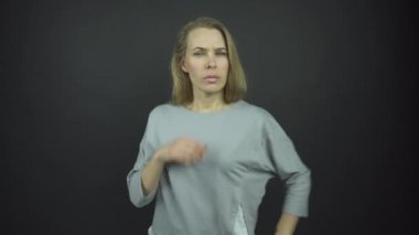 Uzun sarı saçlı, ciddi bir kadın düz görünüyor.