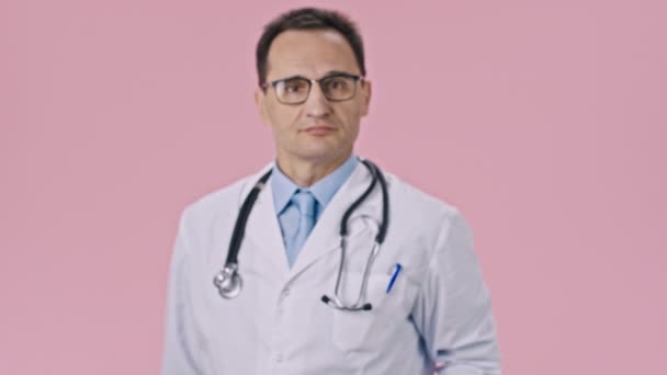 Medicul atractiv în haina medicală și stetoscopul prezintă comprimate cu inimă de cretă — Videoclip de stoc