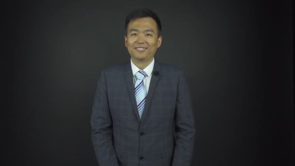 Knap aziatisch acteur in grijs pak glimlacht bij jurk repetitie — Stockvideo