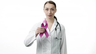 Gülümseyen doktor beyaz arka planda göğüs kanserinin pembe kurdele sembolünü gösteriyor.