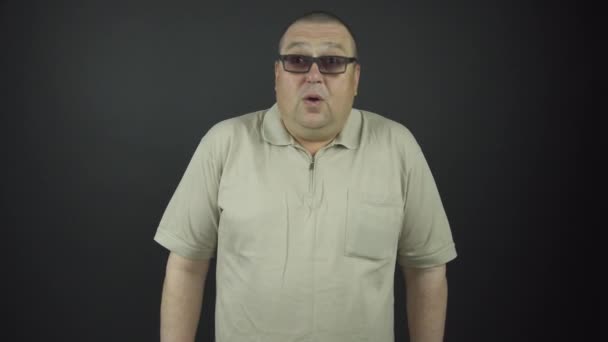 Tlustý muž v hnědých brýlích projevuje překvapivé emoce — Stock video