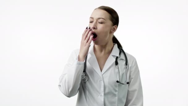 Уставший доктор зевает, надевает портативную подушку на шею, чтобы вздремнуть или вздремнуть, закрывает глаза — стоковое видео