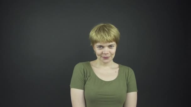 Όμορφη κυρία σε πράσινο t-shirt κινείται και αγγίζει το πρόσωπο — Αρχείο Βίντεο