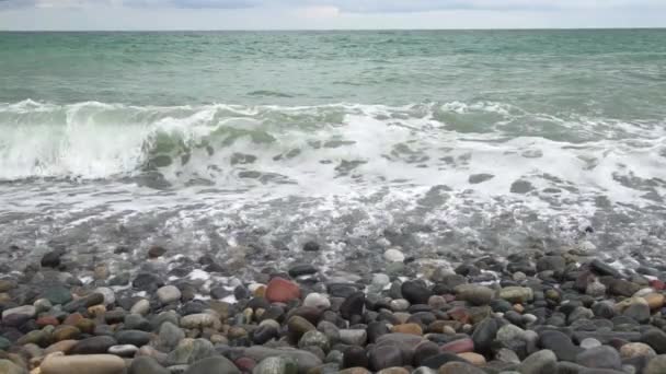 Les vagues de la mer roulent sur le rivage de galets pendant une tempête légère au ralenti au ralenti — Video