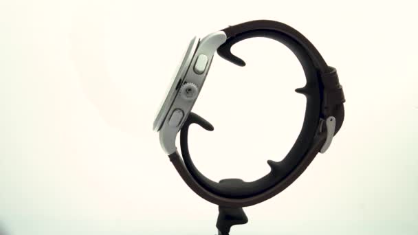 Ібах, Швейцарія 7.04.2020 - Вікторінокс Людина спостерігає за чорним годинником з нержавіючої сталі, який обертається на стенді, ізольованому на білому тлі. — стокове відео