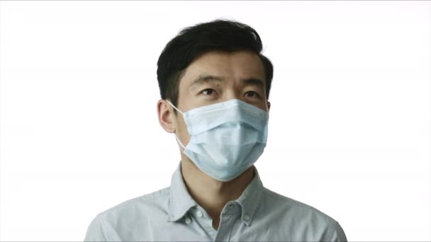 Uomo asiatico in maschera chirurgica contro 2019-nCov si guarda intorno. Malattia pandemica — Video Stock