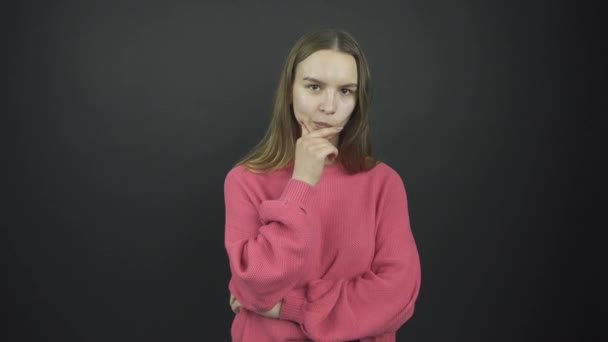 Thoughtful girl with long loose hair holds hand on chin — Stock Video