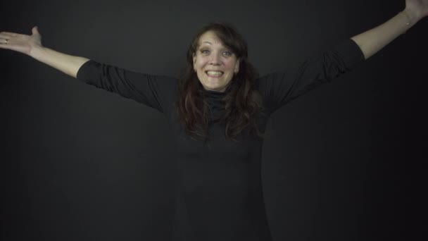 Активная модель в черном пуловере меняет позы и улыбки — стоковое видео