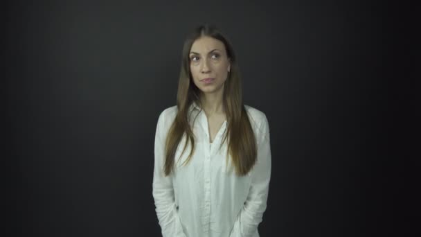 Дама з серйозним обличчям схрещує руки під електричним світлом — стокове відео