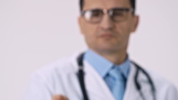 Médico masculino de mediana edad sostiene grandes píldoras verdes en la palma, los derrama en el suelo — Vídeo de stock