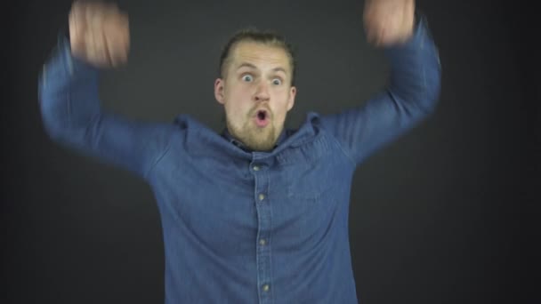 Μοντέρνα γενειοφόρος τύπος σε μπλε πουκάμισο denim σηκώνει τα χέρια — Αρχείο Βίντεο