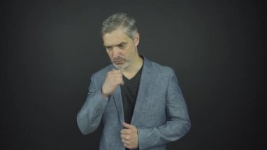 Mavi takım elbiseli ciddi bir adam gri sakallı bir adamla el ele koşuyor.