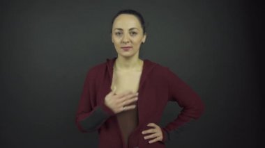 Aktris, göğsünde el ele tutuşan şaşkın kadın rolünü oynar.