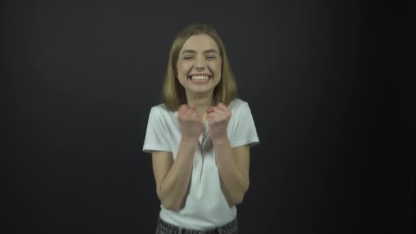 Dívka v bílém tričku skoky a potřesení rukou se štěstím — Stock video