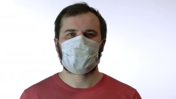 Man removes medical mask against coronavirus, smiles at camera. End of epidemic — Stock Video