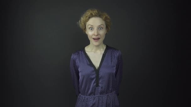 Опытная актриса в синем платье демонстрирует сюрприз — стоковое видео