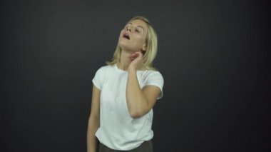 Beyaz tişörtlü sarışın kadın tutku dolu duygular sergiliyor.