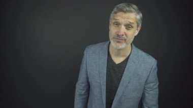 Gri sakallı ve saçlı yakışıklı aktör düzgün görünüyor.