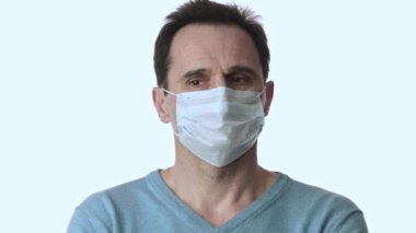 Korunaklı maskeli bir adam koronavirüsten korkuyor. Pandemik pandemik etrafa bakıyor.
