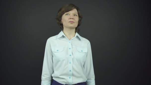 Σοβαρή γυναίκα με πουκάμισο κοιτάζει γύρω και βάζει το χέρι στο ισχίο — Αρχείο Βίντεο