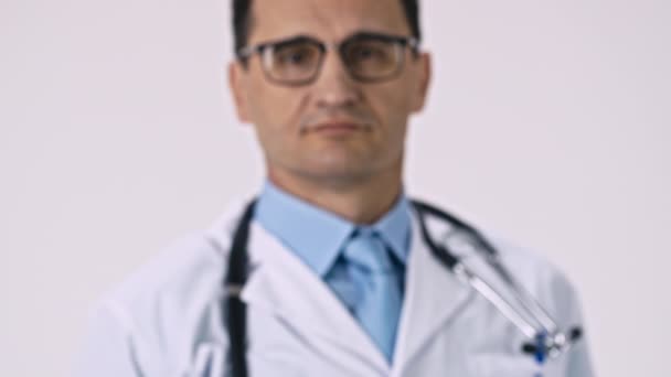 El guapo doctor en abrigo médico y estetoscopio muestra un gran botiquín de primeros auxilios — Vídeo de stock