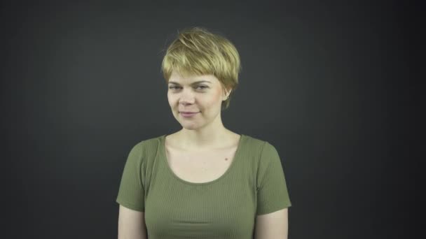 Elegante dama en camiseta verde mira a su alrededor y toca la cara — Vídeos de Stock