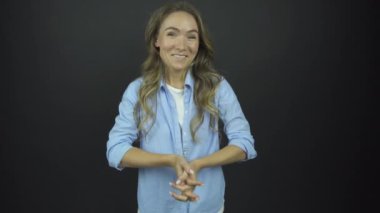 Uzun kahverengi saçlı kız mutlulukla el kaldırıyor.