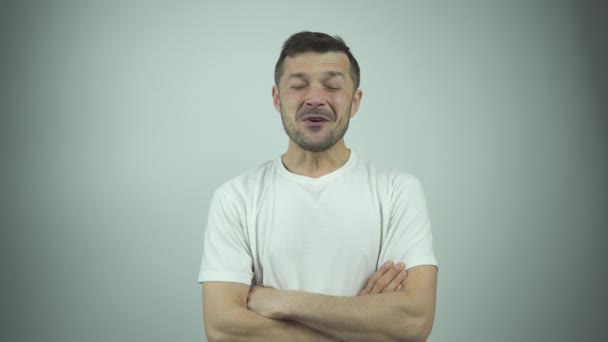 Muskularny facet w białej koszulce podnosi i ściska dłonie — Wideo stockowe