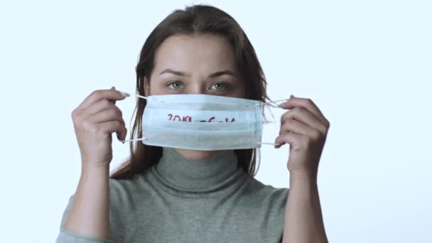 Κορίτσι βάζει σε ιατρική μάσκα με επιγραφή 2019-ncov. Εξάνθημα του κορωναϊού — Αρχείο Βίντεο