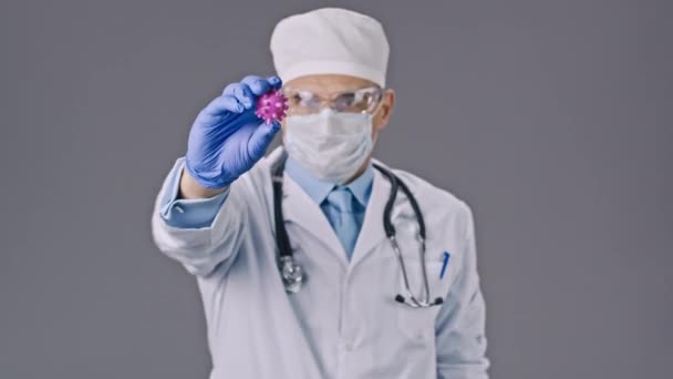 Мужчина-врач в медицинской форме показывает вирусную клетку ковида-19, знак стоп в лаборатории — стоковое видео