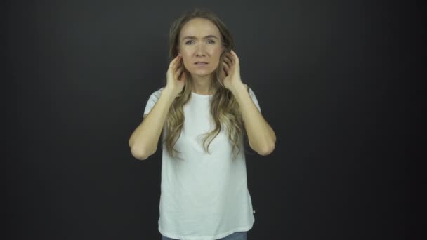 Jeune femme fixe les cheveux longs et croise les mains avec surprise — Video