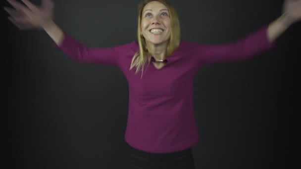 Excited lady in purple raises hands with happiness in studio — Stock Video