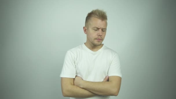 Bonito homem com curto cabelo claro desempenha papel de cara confuso — Vídeo de Stock