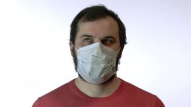 Tıbbi maskeli adam paniğe kapılmış Covid-19 paniğiyle gözleri hızla hareket ettiriyor.