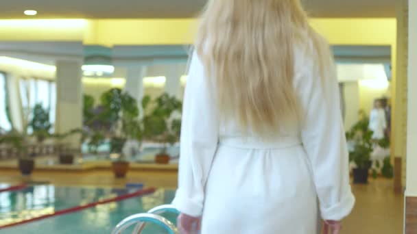 Mujer caucásica toma tratamientos de spa en la piscina del hotel. Estilo de vida saludable . — Vídeos de Stock