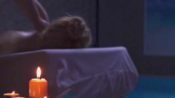 Master massage therapist massage to caucasian woman in the dark by candlelight — Stock Video