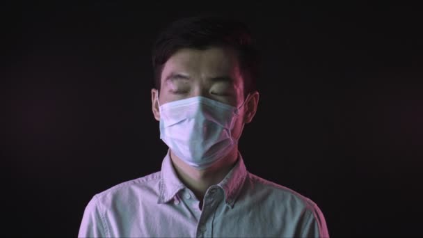 Hombre chino con máscara médica contra la tos covid-19 aparte. Negro backgroung — Vídeo de stock