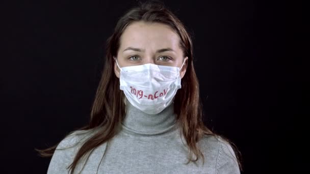 Χαριτωμένο κορίτσι βγάζει μάσκα προσώπου, αναπνέει, κοιτάζει την κάμερα. Παγκόσμιος πανδημικός φόβος — Αρχείο Βίντεο