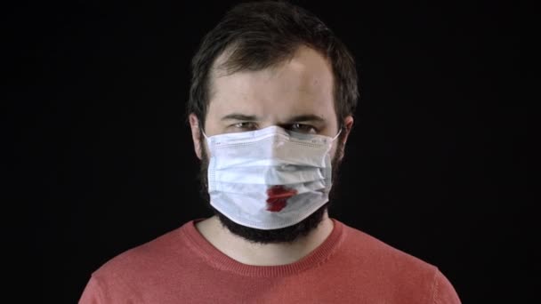 Sjuk man i medicinsk mask med blod på tar på sig ny mask. Konceptet Covid-19 — Stockvideo