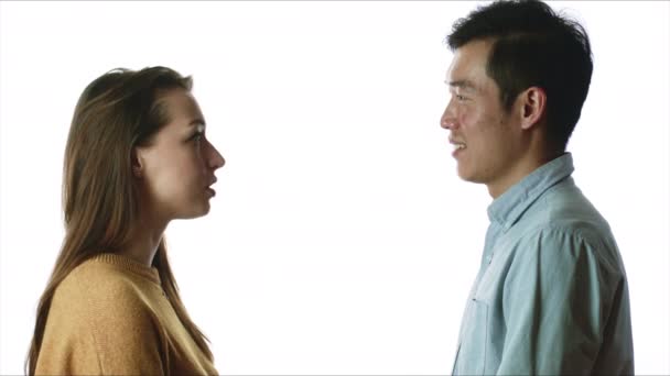 Кавказька жінка і азійський чоловік розмовляють на ізольованому білому фоні — стокове відео