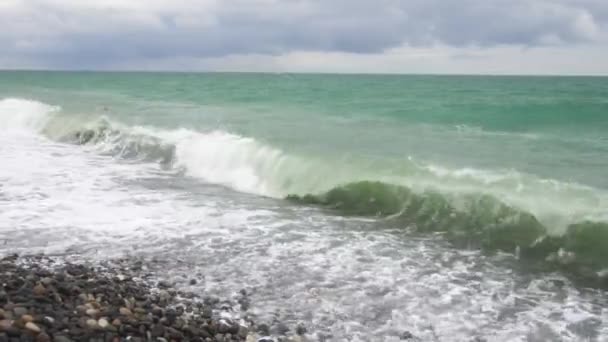 Морські хвилі котиться на березі гальки під час легкої бурі — стокове відео