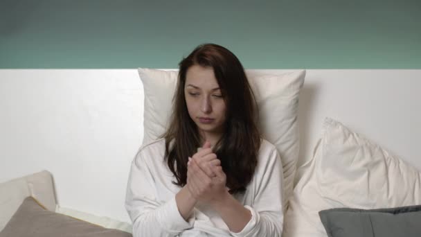Красивая девушка пижама кровать дома дезинфицирует руки с антисептиком и чихает — стоковое видео