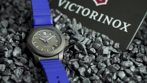 Ibach, Schweiz 7.04.2020 - Victorinox Man klocka rostfritt stål gummiband som ligger på grå småsten — Stockvideo
