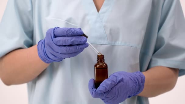 Doctor in sterile gloves holds in his hands a medicine or vaccine for covid 19. — Stock Video