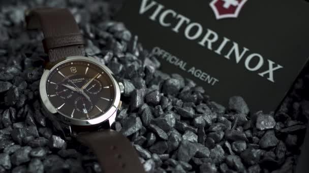Ibach, Švýcarsko 7.04.2020 - Victorinox Man hodinky nerezové pouzdro černé hodiny tvář ciferník ležící na šedé oblázky — Stock video