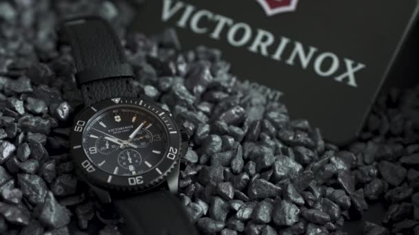 Ibach, Suiza 7.04.2020 - Victorinox Hombre reloj caja de acero inoxidable esfera de la cara del reloj negro acostado en guijarros grises — Vídeos de Stock