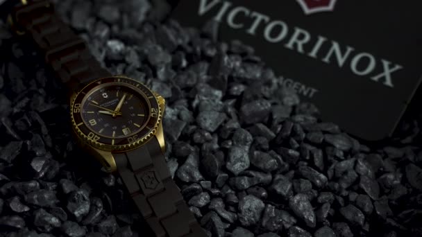 Ибах, Швейцария 7.04.2020 - Victorinox Man часы из нержавеющей стали корпус черный часы наборный резиновый ремень, лежащий на серой гальке — стоковое видео