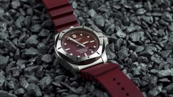 Ibach, Szwajcaria 7.04.2020 - Victorinox Man zegarek ze stali nierdzewnej futerał gumowy pasek leżący na szarych kamyczków — Wideo stockowe